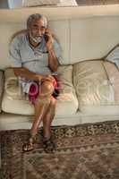 Senior man talking mobile phone in the living room