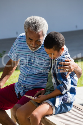 Grandfather and grandson looking at mobile phone