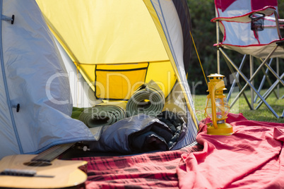 Empty tent and lantern at campsite