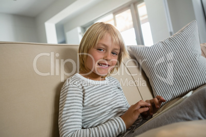 Boy using digital tablet in the living room at home