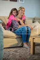 Mother and daughter embracing each other in the living room