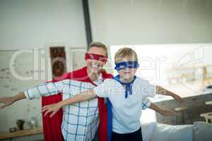 Mother and son pretending to be superhero in living room