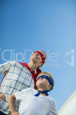 Smiling mother and son pretending to be superhero