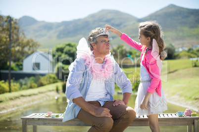 Daughter in angel costume adjusting crown on father head