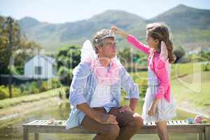 Daughter in angel costume adjusting crown on father head