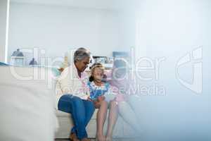 Happy family using digital tablet in living room