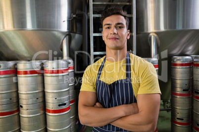 Portrait of smiling worker standing by storage tanks