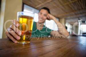 Man holding beer glass at bar counter