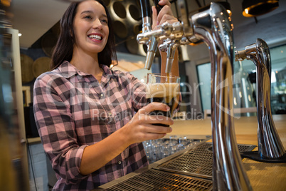 Beautiful barmaid preparing drink at bar