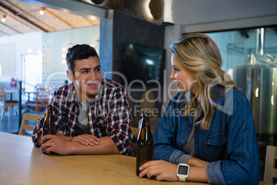 Smiling friends enjoying beer at bar