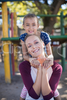 Smiling mother and daughter enjoying at playground