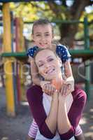 Smiling mother and daughter enjoying at playground