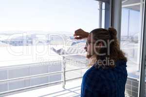 Male executive looking through window in office