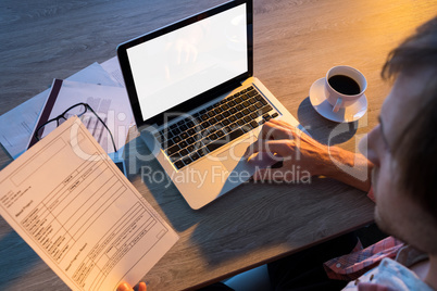 Male executive working over laptop at his desk