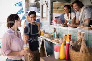 Couple interacting with each other at food truck van