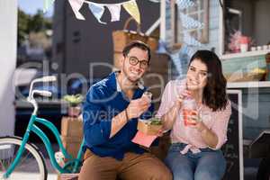 Smiling couple sitting with snacks and juice