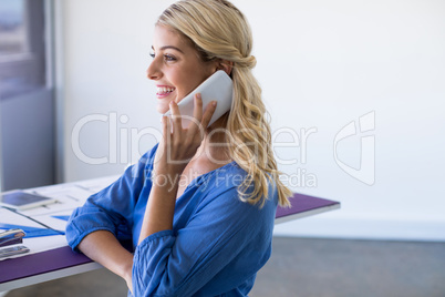 Female architect talking on mobile phone in office