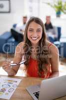 Smiling female executive at desk in the office