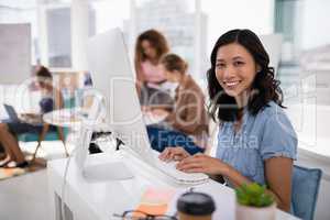 Female executive working on computer at desk in the office