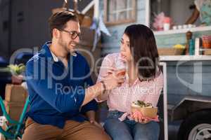 Man feeding juice to woman