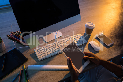 Male executive using digital tablet at his desk