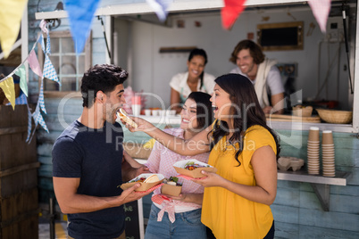 Smiling friends eating snacks