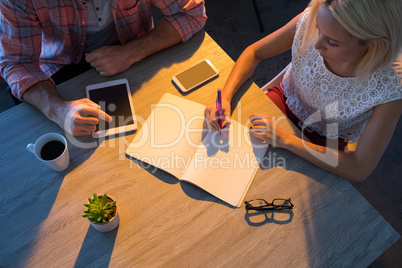 Female executive writing in diary during a meeting