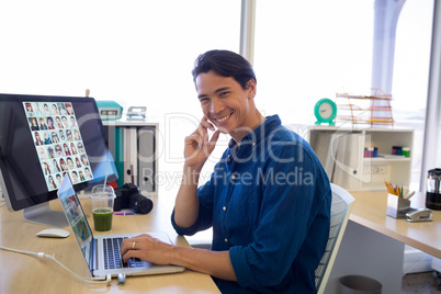 Male executive working over laptop at his desk