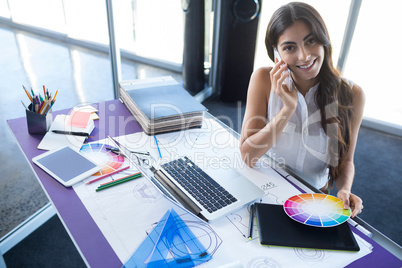 Female executive talking on mobile phone at her desk