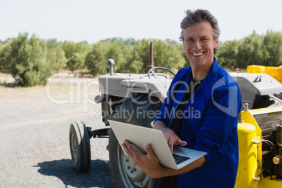Portrait of worker using laptop on road