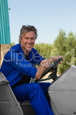 Smiling worker sitting in tractor