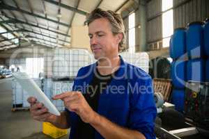Worker using digital tablet in factory