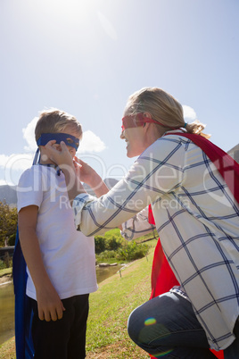 Mother and son pretending to be superhero in the backyard