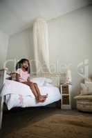 Girl sitting on bed in the bedroom at home