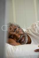 Senior man sleeping on bed in the bedroom