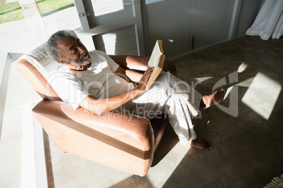 Senior man reading a book at home