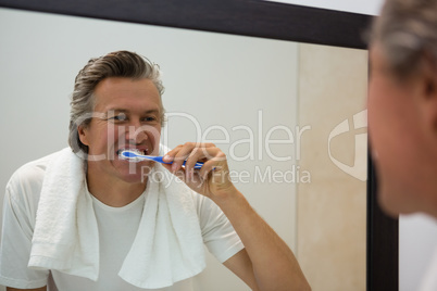 Man brushing his teeth in bathroom