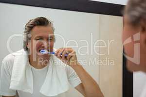 Man brushing his teeth in bathroom