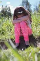 Sad girl sitting in parkland