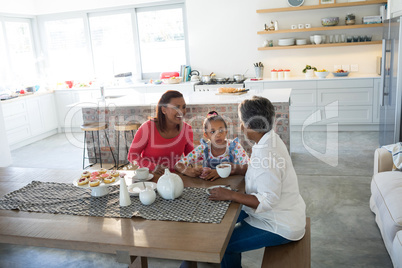 Happy multi-generation family having tea in dining table