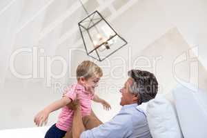 Happy father and son having fun in living room