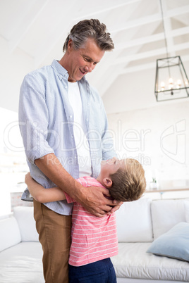 Happy father and son embracing each other in living room