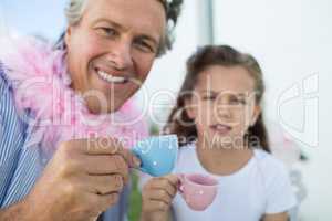 Smiling father and daughter in fairy costume having a tea party