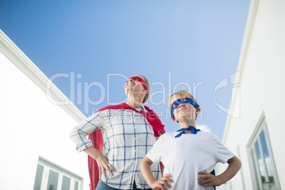 Smiling mother and son pretending to be superhero