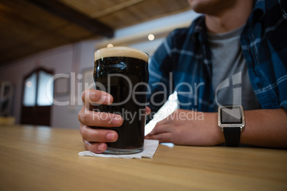 Midsection of customer with beer glass