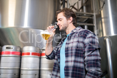 Low angle view of man examining beer