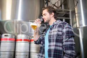 Low angle view of man examining beer