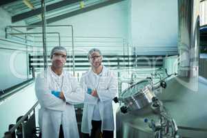 Portrait of scientists with arms crossed standing in factory