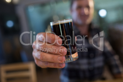Close up of man holding beer glass at bar