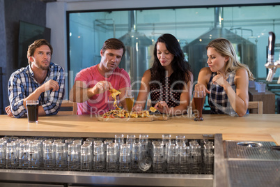Friends having food and drink at bar counter